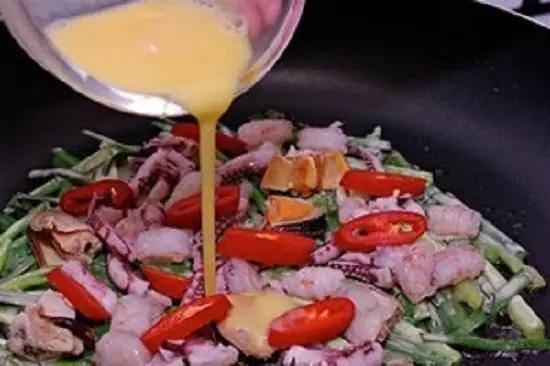 đổ trứng lên trên làm món bánh xèo hải sản Hàn Quốc