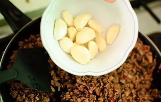 thêm tỏi vào chảo thịt