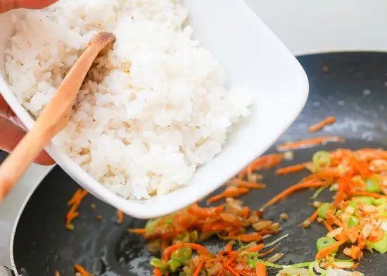 thêm cơm vào chảo rau