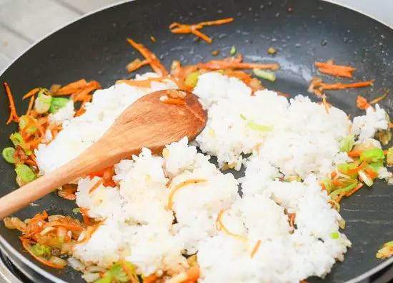 đảo đều cơm với rau củ