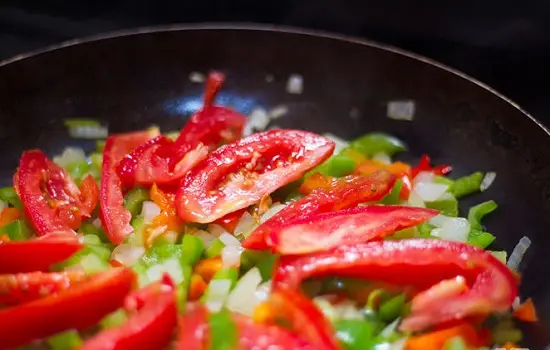 thêm cà chua vào chảo rau củ