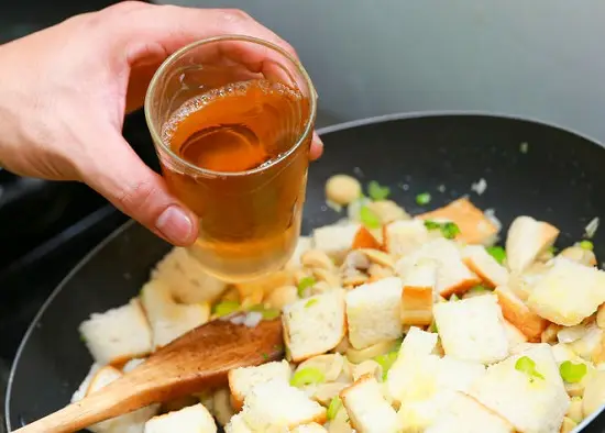 thêm nước dùng gà vào chảo rau củ