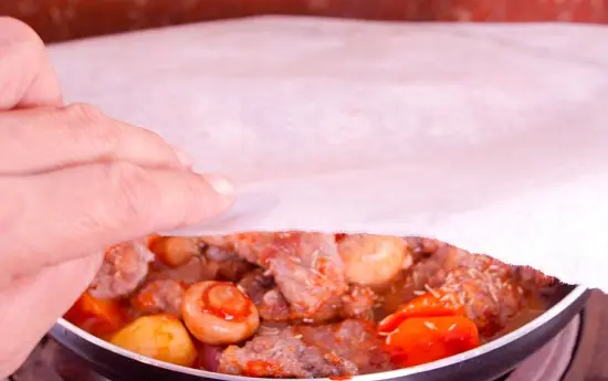 phủ giấy nướng vào chảo thịt