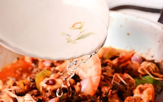 thêm nước dùng gà vào chảo tôm