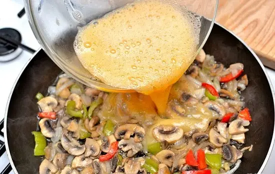 thêm trứng vào chảo rau