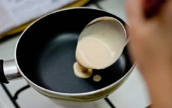 cho bột vào chảo rán qua để làm vỏ nem