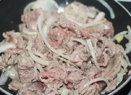 Xào thịt bò với hành tây để làm món phở cuốn