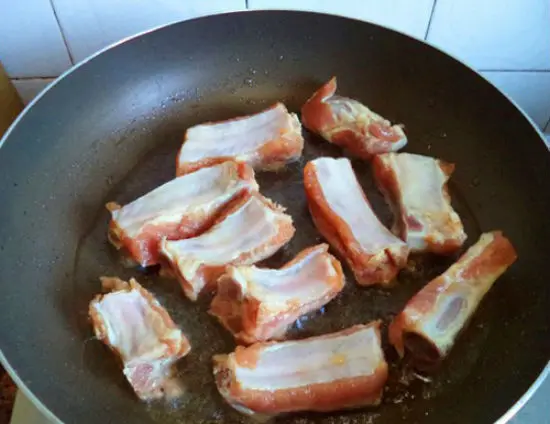 Rán vàng sườn trước khi làm sườn sốt tỏi cay