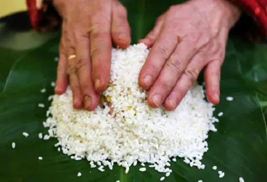 Đổ thêm phần gạo lên trên nhân để gói bánh chưng