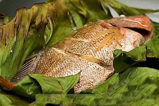Gỡ phần cố định lá chuối ra, thưởng thức món cá hấp chuối thơm ngon, ngọt thịt