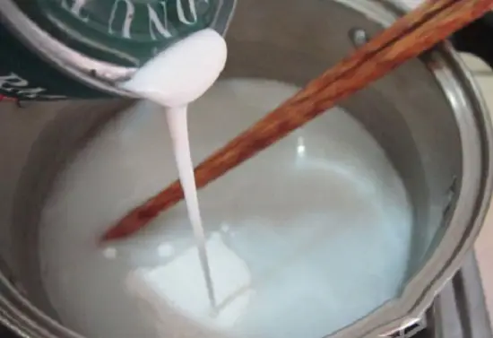 đun nước cốt dừa để làm món chè bí đỏ thơm ngon
