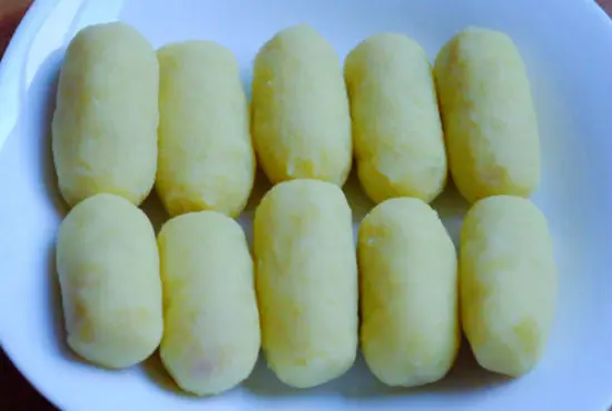 Lần lượt bọc các miếng khoai tây bọc xúc xích cho đến hết